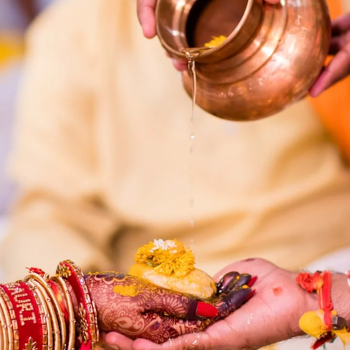 The kanyadaan, water poured from a copper kalash onto joined hands